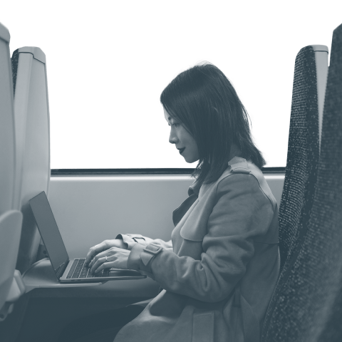 A person on a train working on their laptop