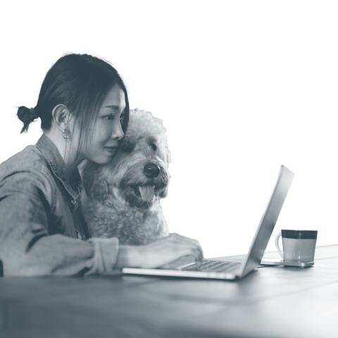 A person with a dog using a laptop